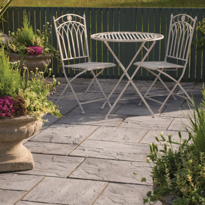 Ashbourne Eco Weathered Grey Concrete Paving with white garden furniture
