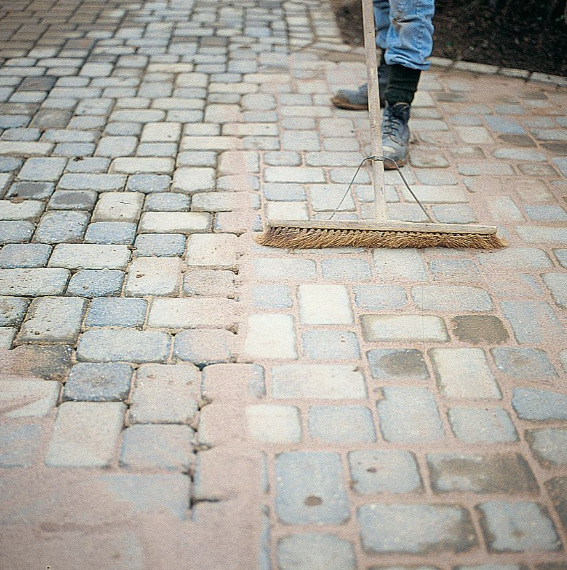 Brushing sand into block paving joints
