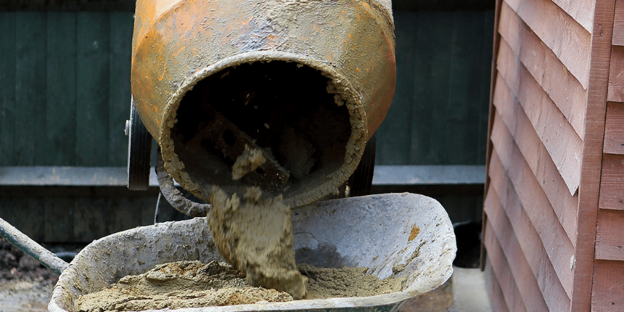 cement mixer with wheelbarrow of mortar